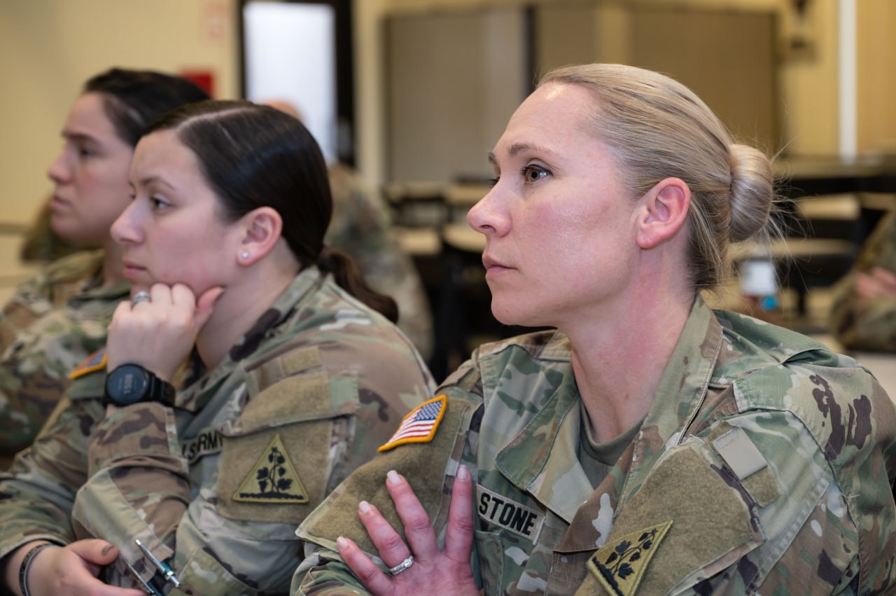 Service members listen as Aaron Stone speaks at the 103rd Airlift Wing Bradley Air National Guard Base in Connecticut